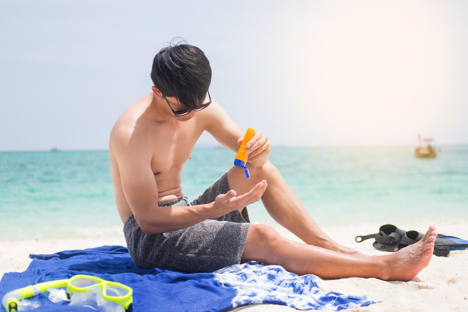 Man applying sunscreen at the beach