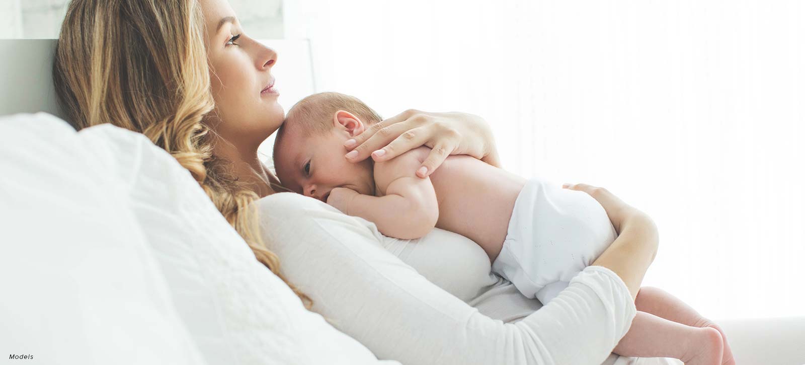 Mommy and baby lying on the bed