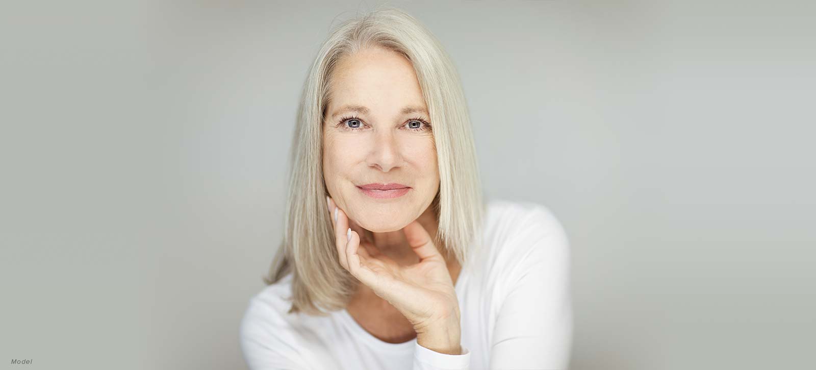 Mature woman with her hand under her jaw